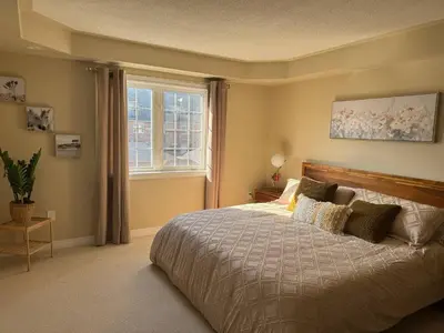 a bedroom with a large bed and a window at Vibrant and Comfy Mississauga Home 20 mins from YYZ in Mississauga