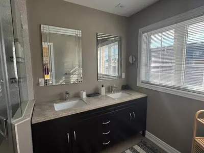 a bathroom with two sinks and a mirror at Vibrant and Comfy Mississauga Home 20 mins from YYZ in Mississauga