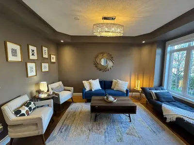 a living room with a blue couch and a table at Vibrant and Comfy Mississauga Home 20 mins from YYZ in Mississauga
