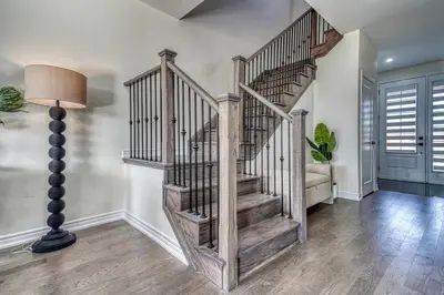 a staircase in a living room with a lamp at Youngs Cove Chalet in Prince Edward County in Carrying Place