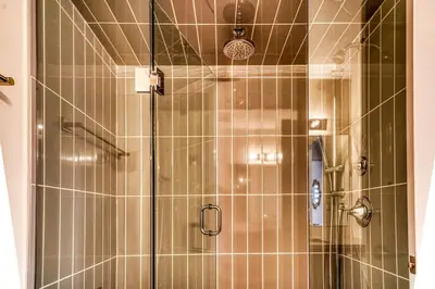 a shower with a glass door in a bathroom at Youngs Cove Chalet in Prince Edward County in Carrying Place