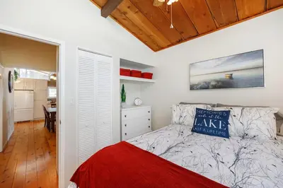 a bedroom with a bed and a dining room at Lovely Little Lake House in Brighton