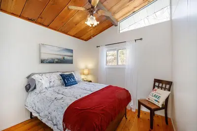 a bedroom with a bed and a ceiling fan at Lovely Little Lake House in Brighton