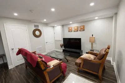 a living room with two chairs and a flat screen tv at Newly Renovated 3BR Orangeville Basement Suite with Private Access, 10 Min Walk to Headwaters Hospital, 5 Min Drive to Mount Alverno! Ideal for Medical Stay, Family Travel & Work Trips! in Orangeville