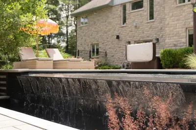 a water fountain in front of a house at Cozy Private Suite with Year-Round Hot Tub in Elora