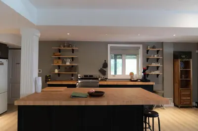 a kitchen with a island in the middle of a room at Cozy Private Suite with Year-Round Hot Tub in Elora