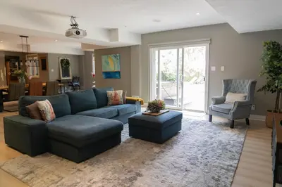 a living room with a blue couch and a chair at Cozy Private Suite with Year-Round Hot Tub in Elora