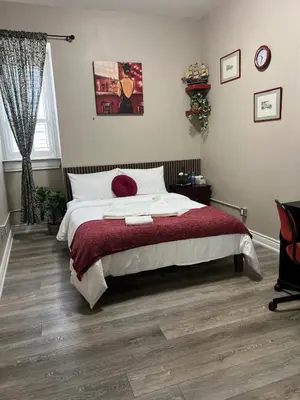 a bedroom with a large bed with a red blanket at Downtown Private Room Central Location in Toronto