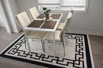 a dining room table with white chairs on a rug at 2024 Built Stylish 3BR Cambridge Townhouse with Free Parking, WiFi, Full Kitchen, Laundry, 8 Min Drive to African Lion Safari! Perfect for Family Travel, Group Trips & Work Stays! in Cambridge