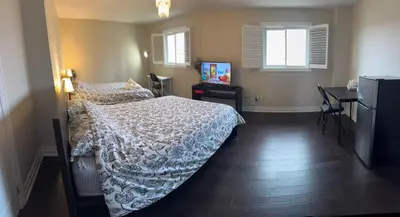 a bedroom with a bed and a television in it at Master bedroom suite on the 2nd floor, city center in Mississauga