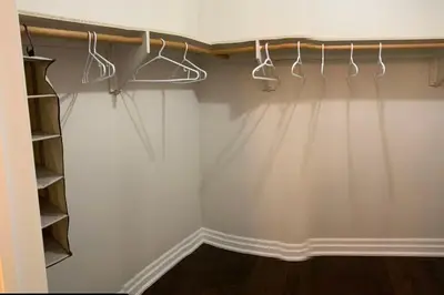 a closet with white walls and white hangers at Master bedroom suite on the 2nd floor, city center in Mississauga