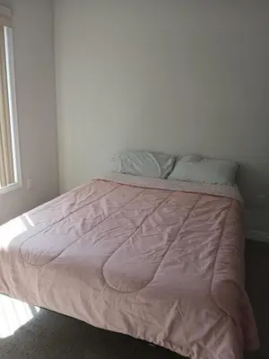 a bed with a pink comforter in a bedroom at Home away from home in Cambridge