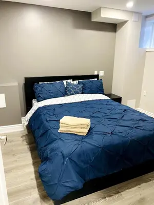 a bedroom with a blue bed with a blue comforter at Cozy 2 Bedroom Apartment in Brampton in Brampton