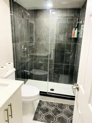 a bathroom with a shower with a toilet and a sink at Cozy 2 Bedroom Apartment in Brampton in Brampton