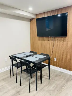 a black table and chairs with a television on a wall at Cozy 2 Bedroom Apartment in Brampton in Brampton
