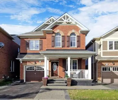 a brick house with a porch and a garage at Cozy 2 Bedroom Apartment in Brampton in Brampton