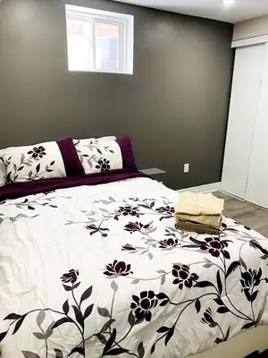a bedroom with a bed with a black and white blanket at Cozy 2 Bedroom Apartment in Brampton in Brampton