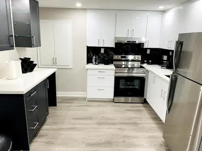 a kitchen with white cabinets and stainless steel appliances at Cozy 2 Bedroom Apartment in Brampton in Brampton