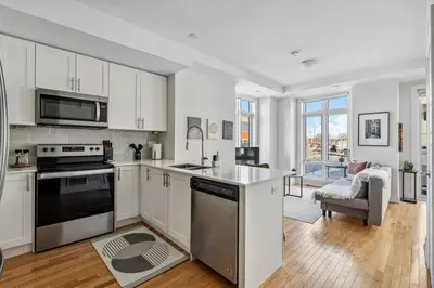 a kitchen with white cabinets and a stove top oven at Stunning 2BR Toronto Retreat, Patio & Parking in Toronto