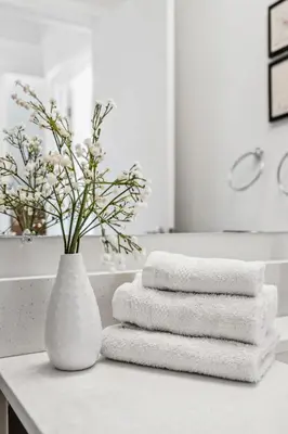 a white vase with towels on a counter in a bathroom at Stunning 2BR Toronto Retreat, Patio & Parking in Toronto