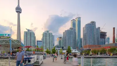 a group of people walking on a pier near a city at Downtown Queen and King St - Lower Suite in Toronto