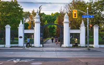a white gate with people walking in front of it at Downtown Queen and King St - Lower Suite in Toronto