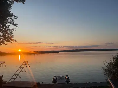 two boats floating on a lake at sunset at Rice Lake Retreat in Roseneath