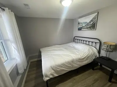 a bedroom with a bed and a lamp and a window at Rice Lake Retreat in Roseneath