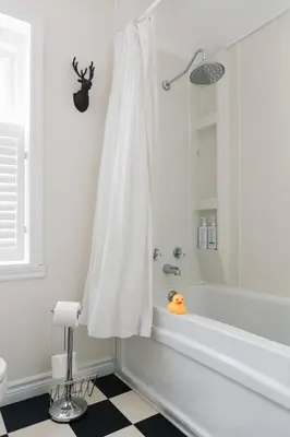 a white bathroom with a tub and a shower at The County Queen - Historic Home in Picton in Picton