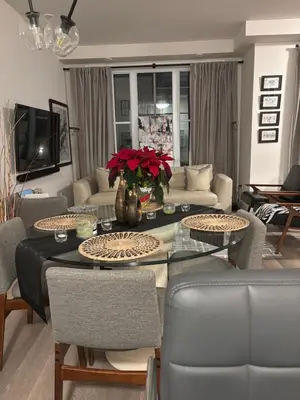 a living room with a table and couches at Beautiful Quaint Home in Port Credit, Mississauga in Mississauga