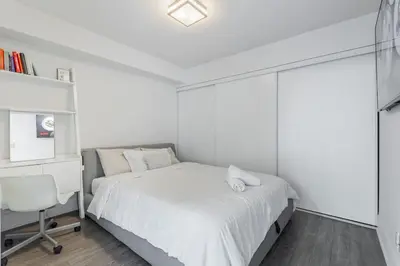 a bedroom with a bed and a desk and a chair at Downtown CN Tower View Condo with Pool Hot tub and Gym in Toronto