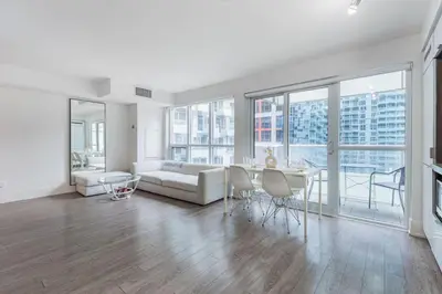 a white living room with a couch and a table at Downtown CN Tower View Condo with Pool Hot tub and Gym in Toronto