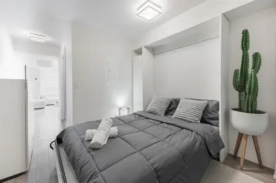 a bedroom with a large bed and a cactus at Downtown CN Tower View Condo with Pool Hot tub and Gym in Toronto