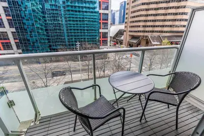 a balcony with two chairs and a table on a balcony at Downtown CN Tower View Condo with Pool Hot tub and Gym in Toronto