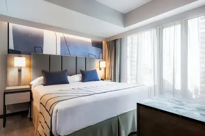 a hotel room with a large bed and a window at Riu Plaza Toronto in Toronto