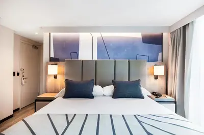 a bedroom with a large white bed with blue pillows at Riu Plaza Toronto in Toronto
