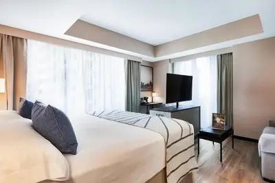 two beds in a hotel room with a flat screen tv at Riu Plaza Toronto in Toronto