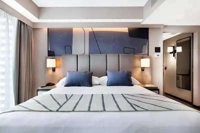 a bedroom with a large white bed with blue pillows at Riu Plaza Toronto in Toronto