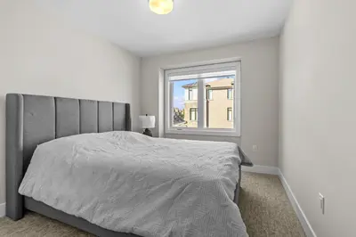 a white bedroom with a bed and a window at Luxury Townhome in Oakville