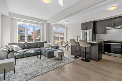 a living room with a couch and a kitchen at Luxury Townhome in Oakville