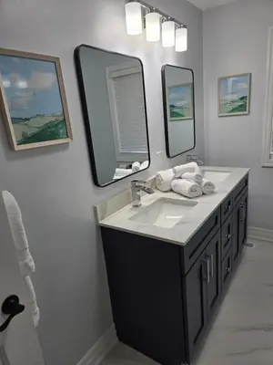 a bathroom with a sink and two mirrors at Streetsville Retreat - Prime Location in Mississauga