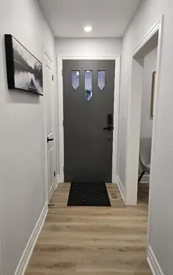 a hallway with white walls and a door with windows at Streetsville Retreat - Prime Location in Mississauga