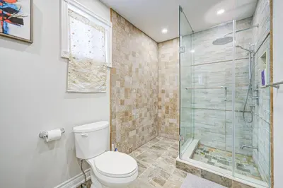 a bathroom with a toilet and a glass shower at Upper-Level Classic House in Richmond Hill in Richmond Hill