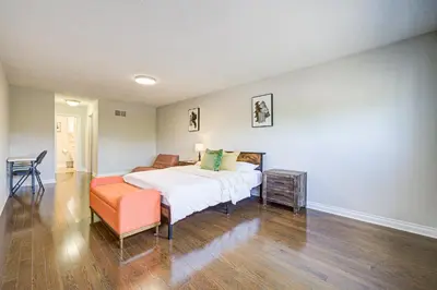 a bedroom with a bed and an orange chair at Upper-Level Classic House in Richmond Hill in Richmond Hill