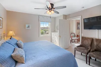a bedroom with a blue bed and a ceiling fan at John & Gate House boutique Bed and Breakfast in Niagara on the Lake