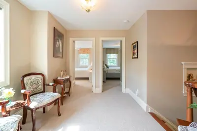 a living room with a chair and a table at John & Gate House boutique Bed and Breakfast in Niagara on the Lake