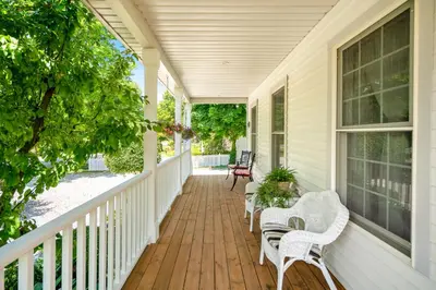 a porch with wicker chairs and chairs on a house at John & Gate House boutique Bed and Breakfast in Niagara on the Lake