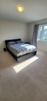 a bedroom with a bed in a room with a window at Stay 15 mins from Niagara Falls-5 Bedroom nights Inn in Thorold
