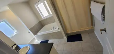 a bathroom with a tub and a sink and a toilet at Stay 15 mins from Niagara Falls-5 Bedroom nights Inn in Thorold