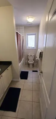 a bathroom with a toilet and a window at Stay 15 mins from Niagara Falls-5 Bedroom nights Inn in Thorold